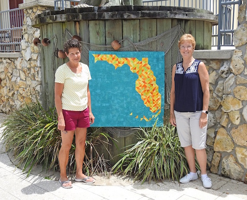 Linda Hungerford and Becky Chianese display an award winning quilt