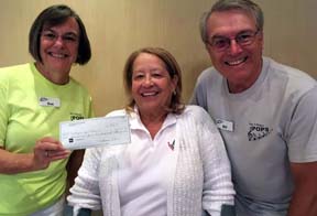 Sue Davis, left, and Bill Davis of The Villages Pop Chorus make a donation to Marie Bogdonoff Founder and President of Villagers for Veterans.