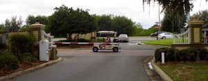 A golf cart passes by the gate at the entrance to the Village of Bridgeport at Lake Sumter.