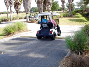 A golf cart travels over a speed bump as it prepares to descend into a tunnel near Mallory Hill Country Club.