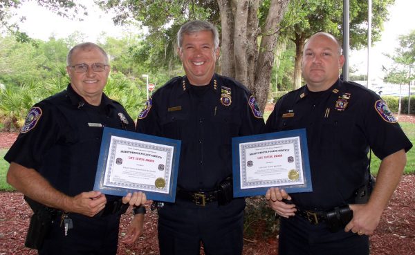 Chief Chris McKinstry, center, presents awards to Officer Ron Michaud, left and Capt. Jason Brough.