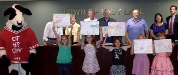 Students show off their winning posters at Monday's Lady Lake Commission meeting.