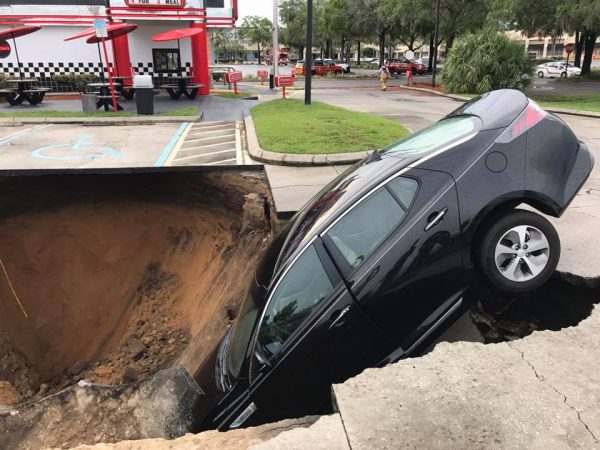 A massive sinkhole swallowed a car Saturday at Checkers restaurant in Ocala.