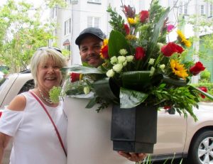 Linda terBurg and Fernando Varela, holding terBurg’s beautiful bouquet in appreciation of her leadership of It Takes a Village.