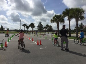 Camp Villagers participating in a "Slow Race" to learn how to balance on bikes at the Bike Rodeo program