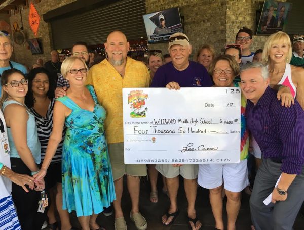 Wildwood Middle High School Principal Richard Hampton and more than 20 teachers present at the event receive a check from The Villages Parrot Heads.