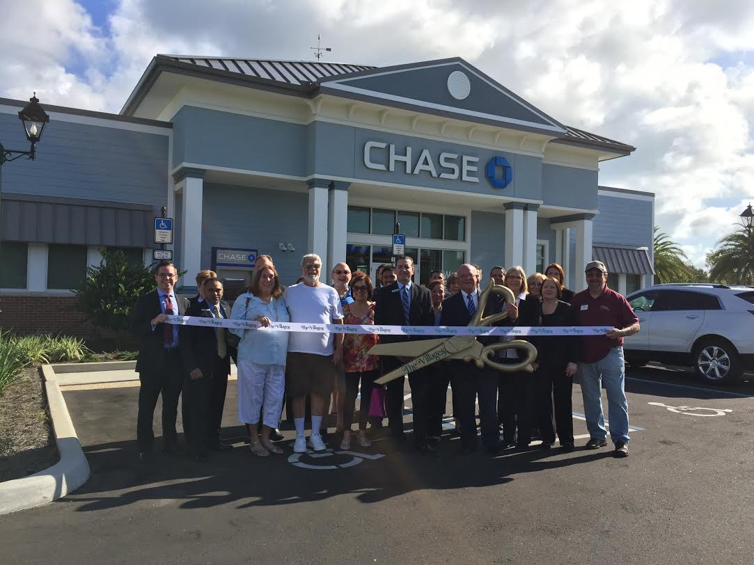 Invited villagers, local Chase executives and Sen. Dennis Baxley hold a Villages ribbon in honor of the newest bank.