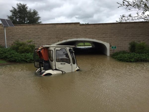 A golf cart attempts to pass through the flooded tunnel near Havana Country Club.