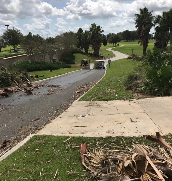 Golf carts wade into the water that has flooded a tunnel in The Villages