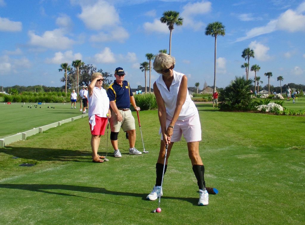 Pat Parrot putting with friends Bette and Lonnie Atwood looking on.