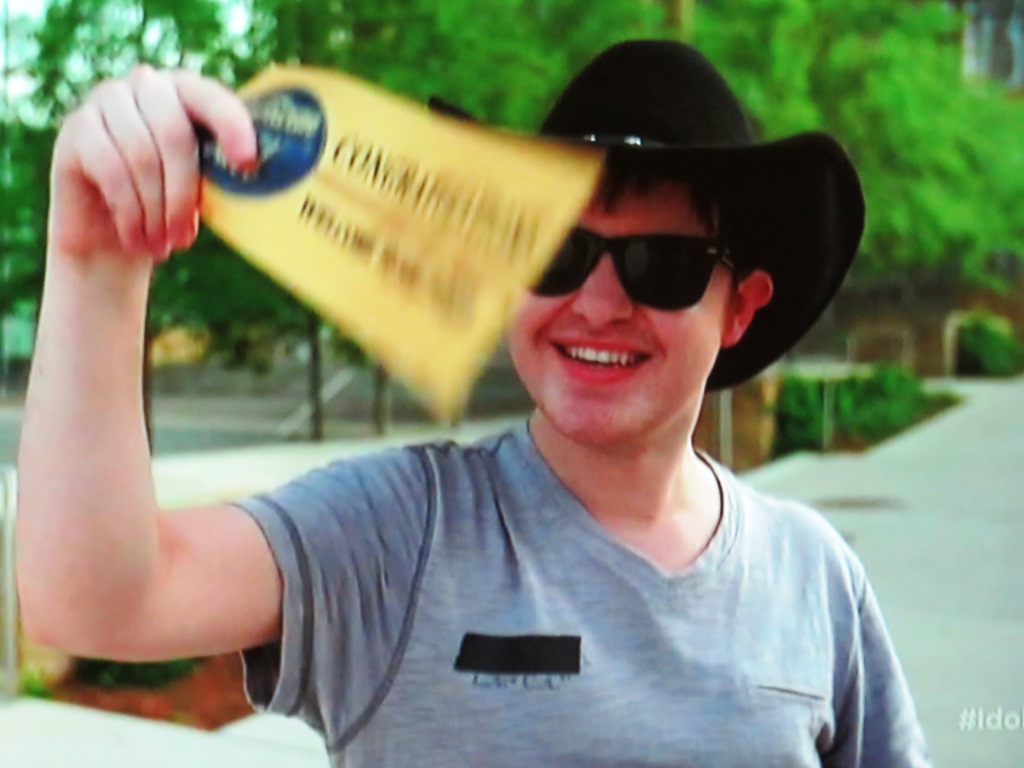 Garrett Miles holds up his ticket to the Hollywood round of American Idol.