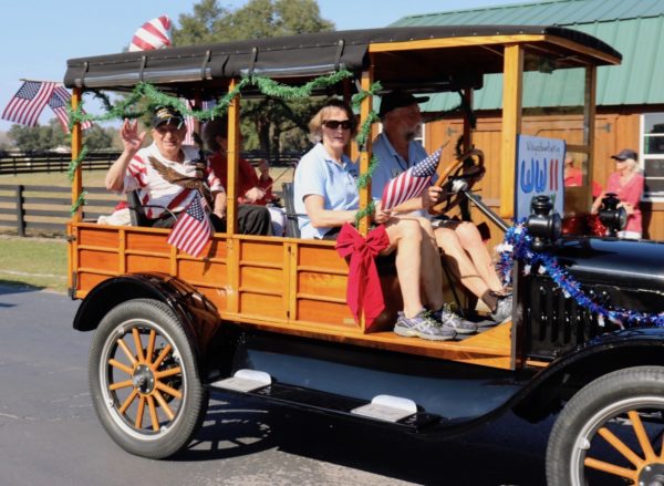 Villager Irving Locker who was part of the D Day invasion waves to the crowd from an antique vehicle in the Christmas parade