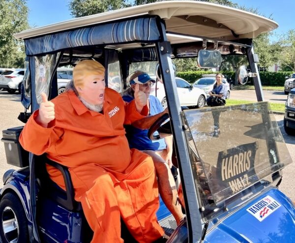 A participant wearing a Donald Trump costume, complete with orange jumpsuit, took part in the golf cart parade