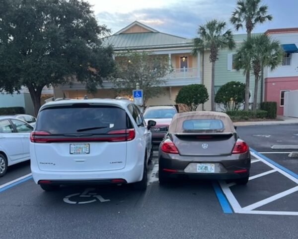 The driver of this white van, who has a handicapped placard, was surprised when he returned to his vehicle to see another driver had doubled up with him