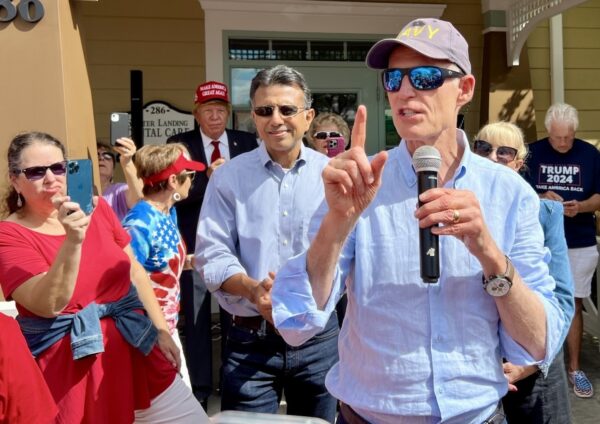 U.S. Sen. Rick Scott, holding microphone, spoke to a group of Villagers on Saturday